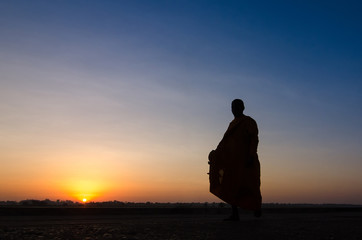 Fototapeta premium Silhouette of monk feet walking on concrete ground for people of