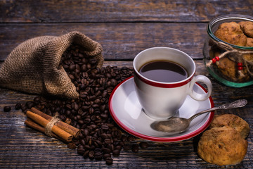 Coffee cup, coffee beans and biscuits, cookies  on wooden background