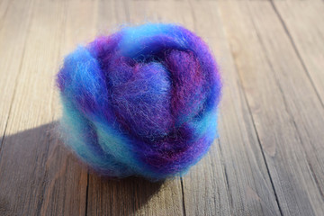 This is a colorful nest of hand dyed wool roving made from the fleece of a sheep.