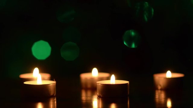 candles on table in dark, festive decoration of room, against backdrop of colorful glowing bokeh