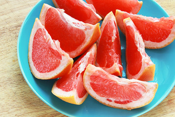 Вкусные спелые дольки грейпфрута на тарелке и деревянной доске. диета для похудения