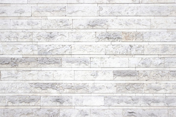 white wall of stone blocks, light texture as background