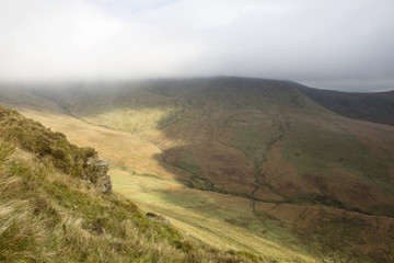 The Path Along the Escarpment. A public walking path goes along the escarpment of Craig y Fan Ddu in the Brecon Beacon National Park taking no notice of the long drop to the valley below.