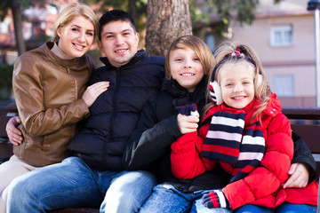 Family sitting on bench outdoors