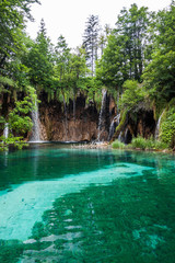 Waterfall flowing into the forest lake. Plitvice, National Park,