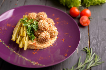 Asian dish with balls of sesame on purple plate