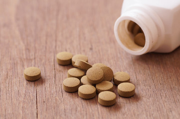 Fototapeta na wymiar herb medicine in pill on wood background