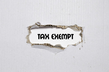 The word tax exempt appearing behind torn paper