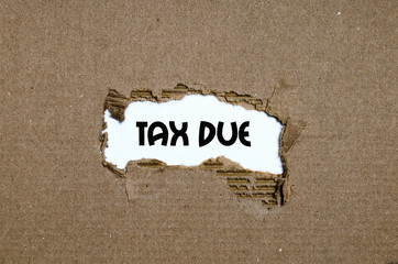 The word tax due appearing behind torn paper