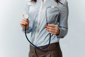 Medical doctor woman on a blue background holding stethoscope focus the