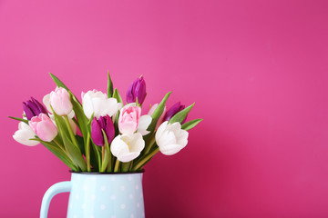 Naklejka na ściany i meble Bouquet of tulips in jug on pink background