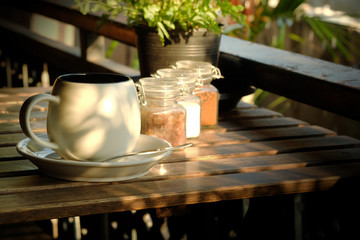 white cup of coffee with sugar on wooden table in the morning background