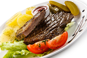 Grilled steaks, French fries and vegetables 