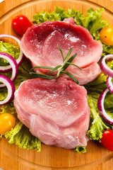 Raw meat on cutting board and vegetables 