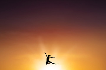Carefree woman leaps at dusk time