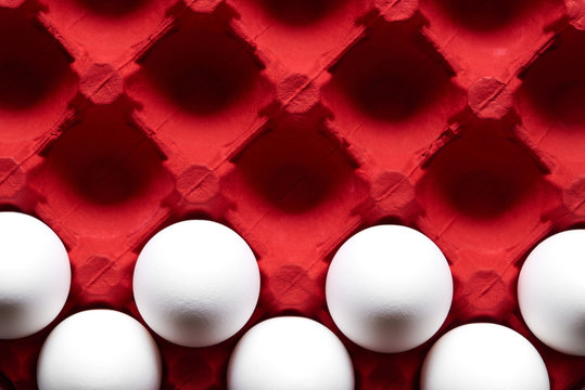 White eggs pattern in red color carton pack direct above view