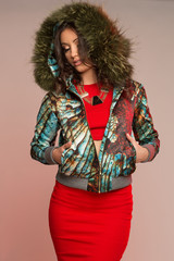 Women in colourful jacket with triangle, black necklace