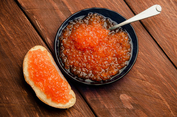 blue plate. wood planks. Sandwich with butter and caviar