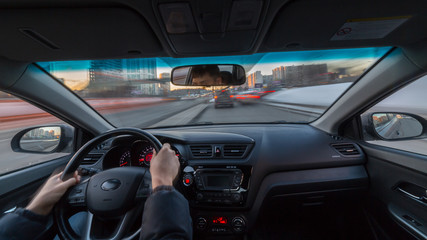 City road view from inside car natural light street and other cars is motion blurred