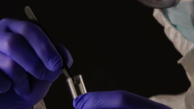 Forensic scientist putting hair in evidence tube during crime scene investigation