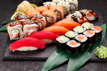 Japanese cuisine. Sushi set on a stone plate and dark concrete background
