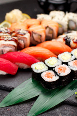 Japanese cuisine. Sushi set on a stone plate and dark concrete background