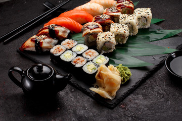 Japanese cuisine. Sushi set on a stone plate and dark concrete background