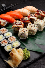 Japanese cuisine. Sushi set on a stone plate and dark concrete background