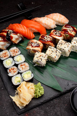 Japanese cuisine. Sushi set on a stone plate and dark concrete background