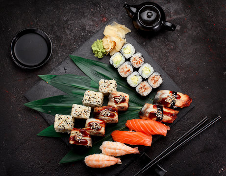Japanese cuisine. Sushi set on a stone plate and dark concrete background