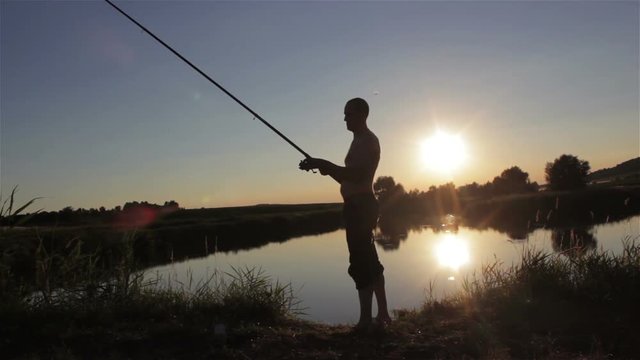 fisherman at sunset/fisherman on the lake fishing at sunset