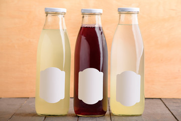 Juice bottle colored glass mock up on wooden table design template