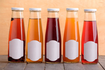 Obraz na płótnie Canvas Juice bottle colored glass mock up on wooden table design template