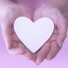 Obraz premium womans hands showing a white heart