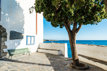 traditional old square in the street of Cadaques village, Spain with view on blue mediterranean sea...
