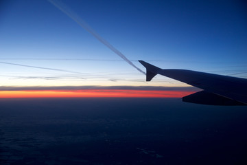Fototapeta na wymiar FRANKFURT, GERMANY - JAN 20th, 2017: View on the sunset, germany during winter and airplane wing from the inside the plane during my Lufthansa flight to Oslo.
