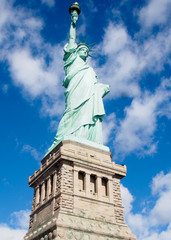 The Statue of Liberty on a sunny day in the harbor of New York City.