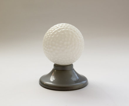 Golf ball on a stand on white background