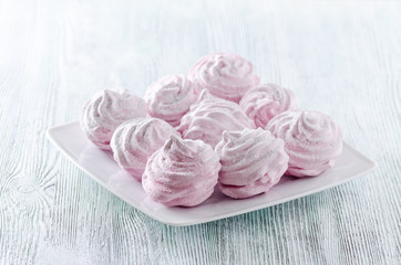 lovely pastel rose meringues, zephyrs, marshmallows on the wooden vintage table