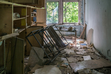 abandoned class room with furniture and debris in Pripyat School, Chernobyl