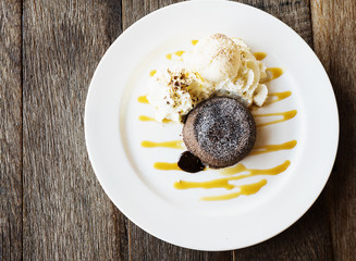 Chocolate lava cake in white plate on old wooden table