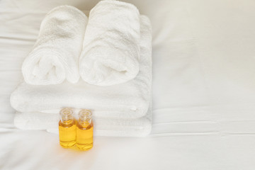 Obraz na płótnie Canvas Hotel towel with shampoo and soap bottle set on white bed