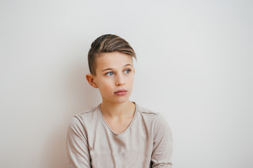 Portrait of a young boy looking away on the light background