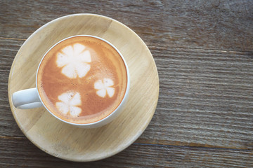 Vintage hot coffee cup with nice Latte art decoration on old wooden texture table