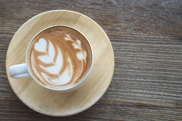 Vintage hot coffee cup with nice Latte art decoration on old wooden texture table