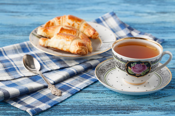croissant and tea in mug. Breakfast concept