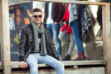 Obraz premium Portrait of handsome young man wearing sunglasses sitting in front of his friends