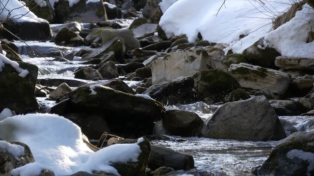Mountain creek in winter. Melting snow in spring