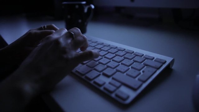 woman typing on a keyboard in the night 