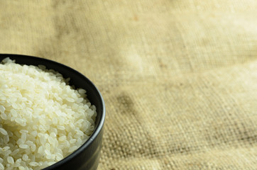 japanese rice in a black bowl on background
